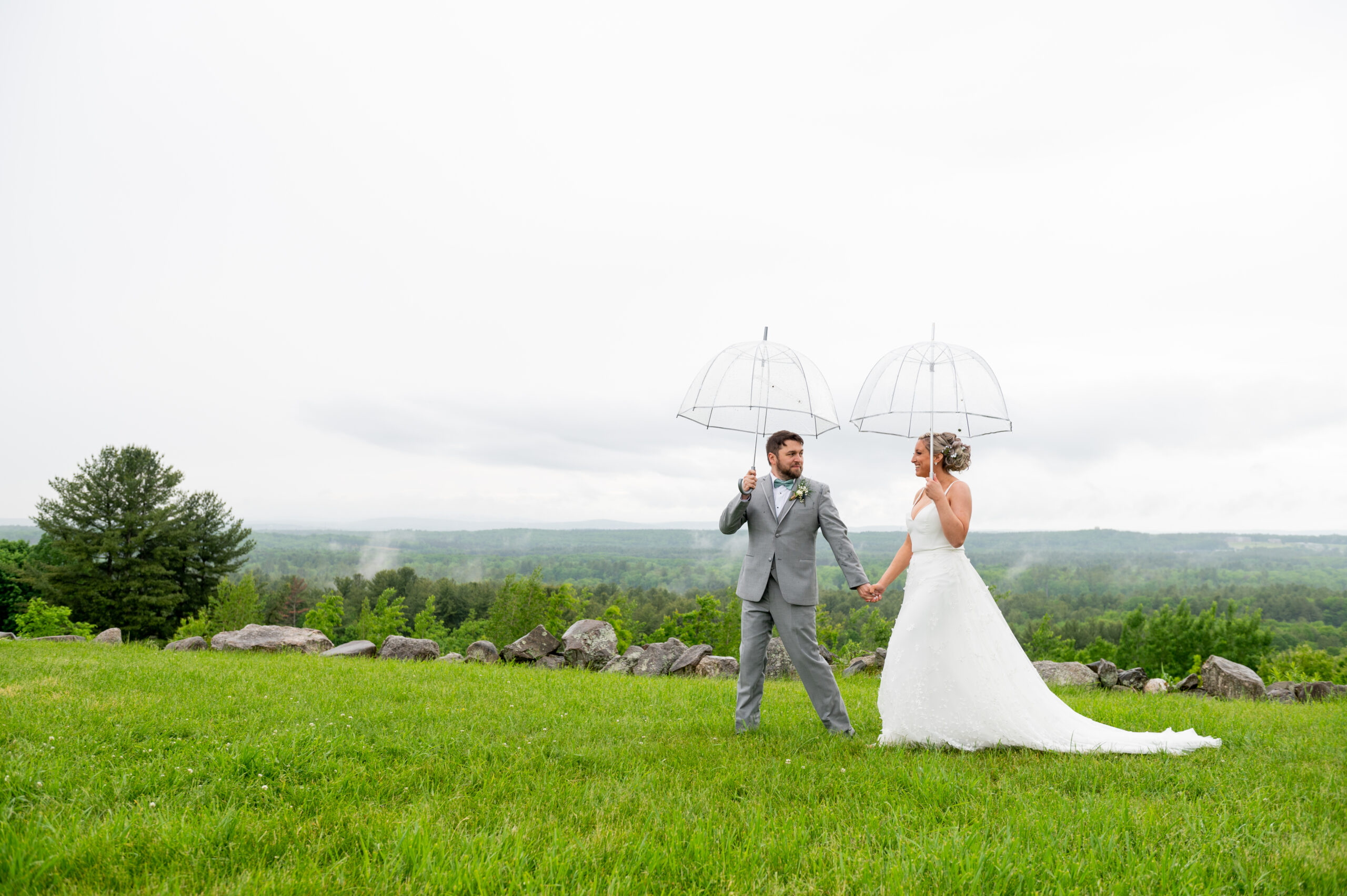 bride and groom walking with umbrellas on their Rainy Day Wedding 