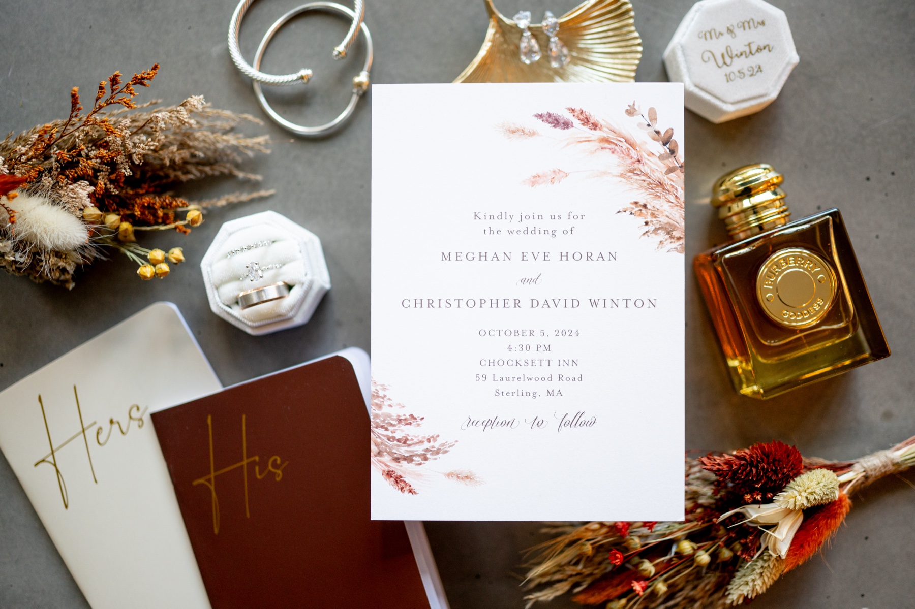 flat lay of wedding invitation, wedding vow books, and wedding rings