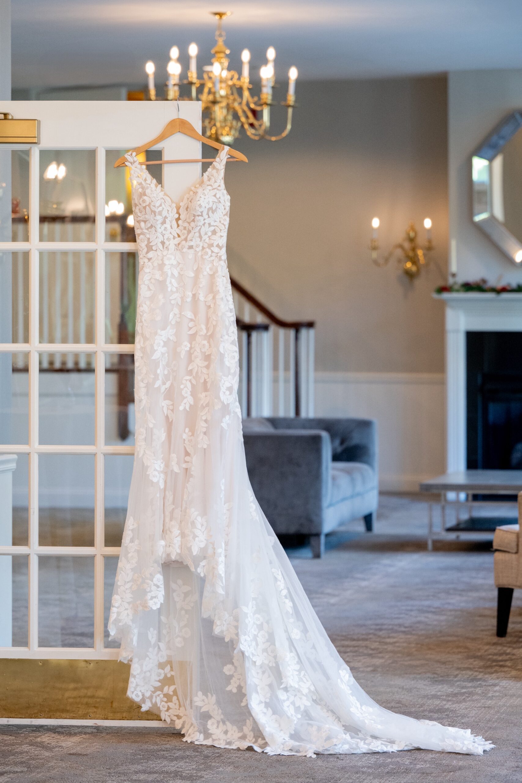 lace wedding dress hanging from a chandelier in the chocksett inn 