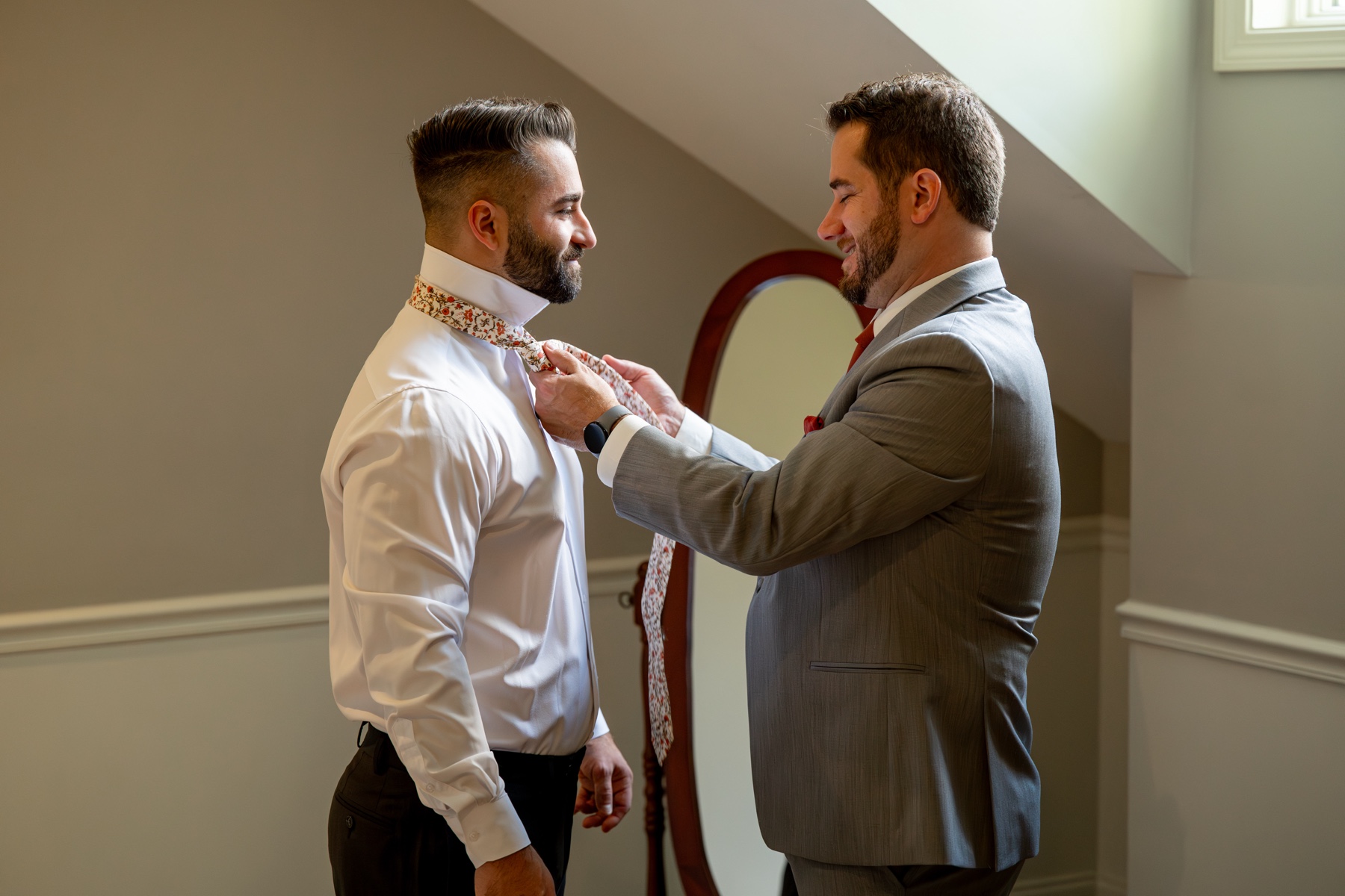 groomsman tying the groom's tie on his chocksett inn wedding day