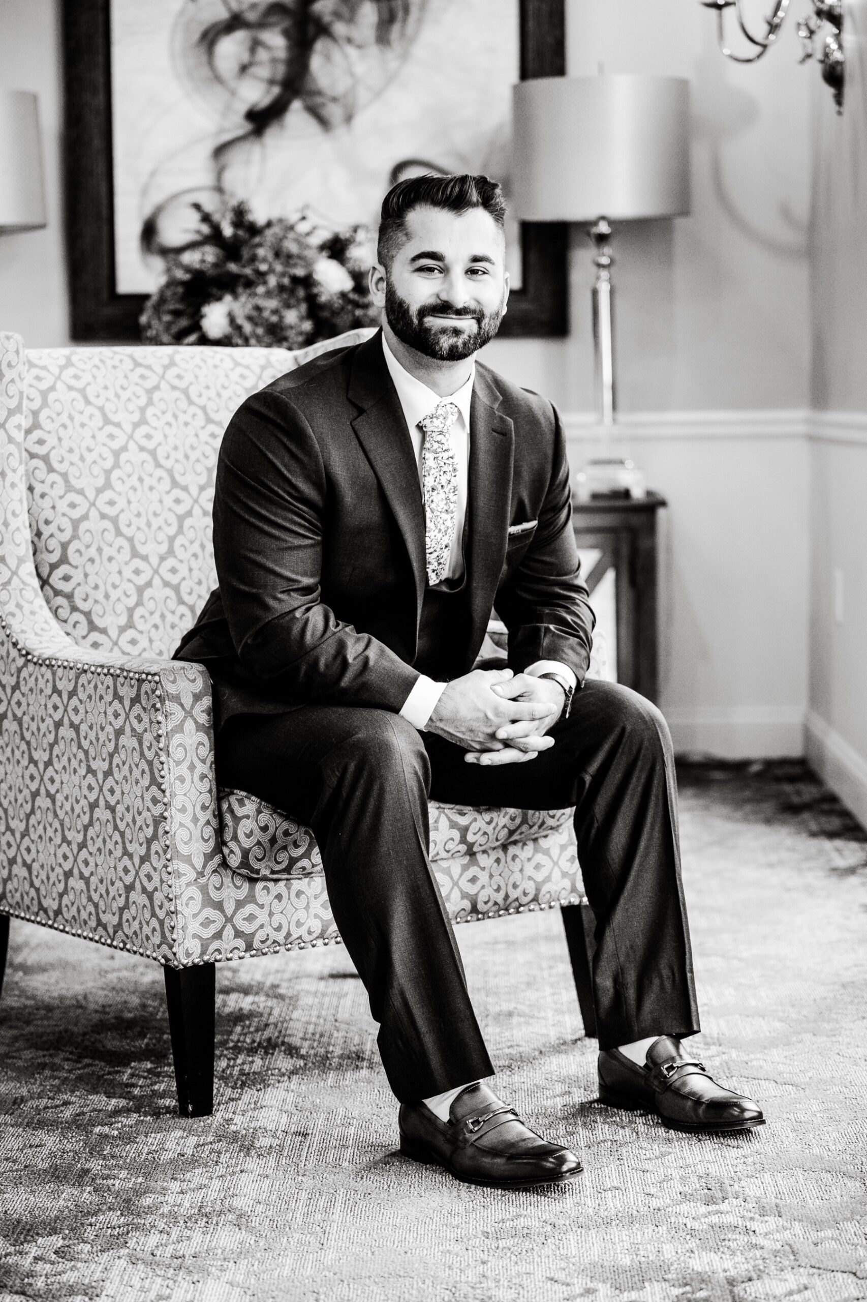 groom sitting in his chair in his wedding day suit