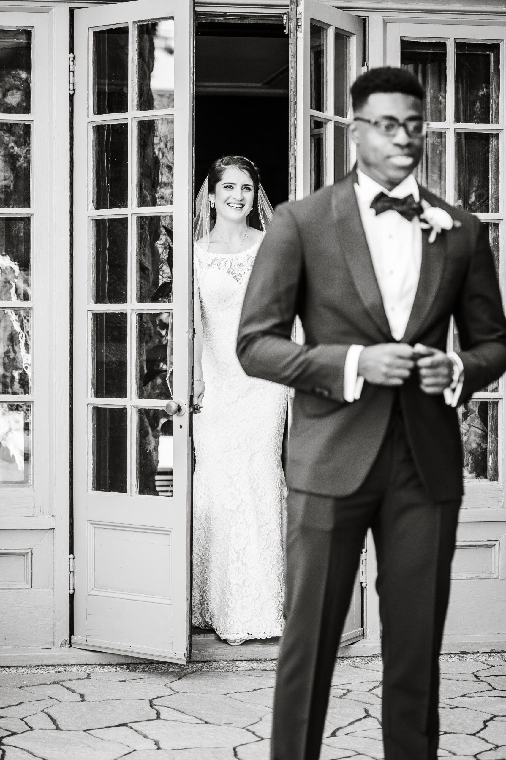 bride standing behind the groom just before her turns around for the first look on their wedding day