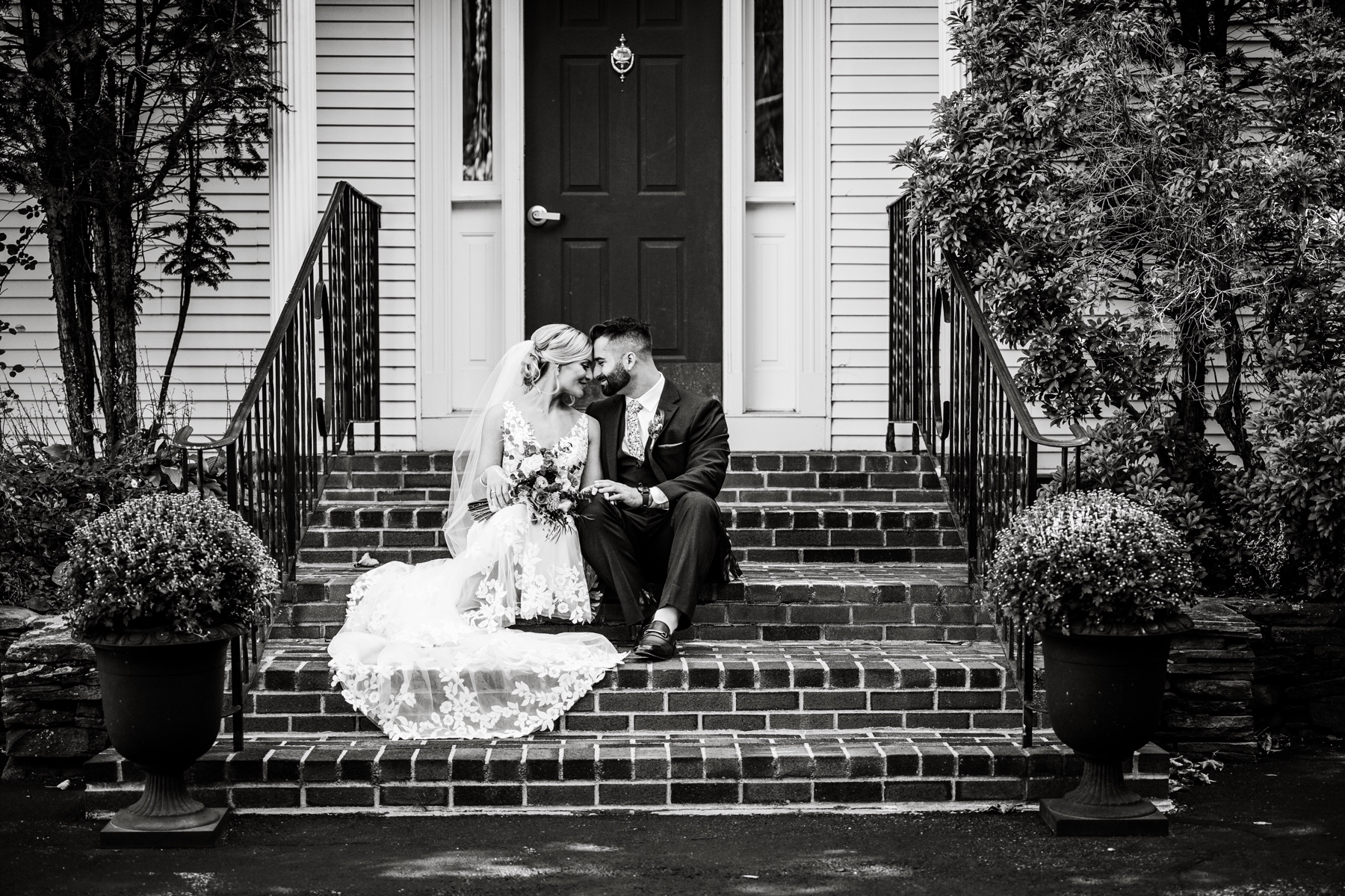 bride and groom sitting on stairs of the chocksett inn for their wedding day
