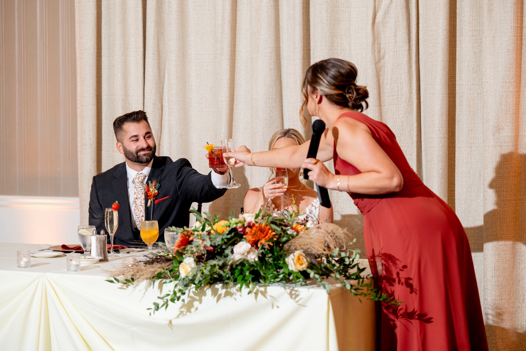 bridesmaid cheersing with the groom after her maid of honor toast