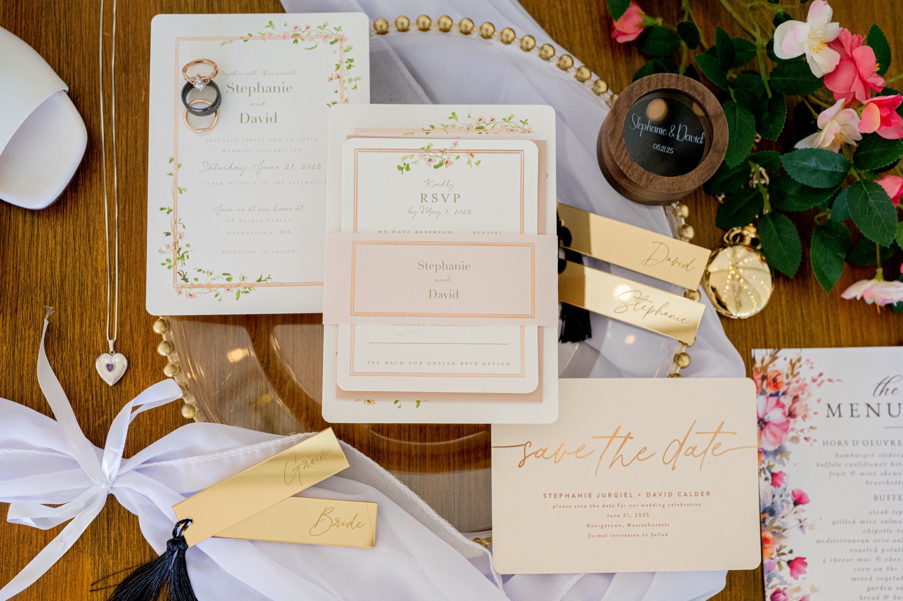 a flatlay of white wedding invitations and bridal details 