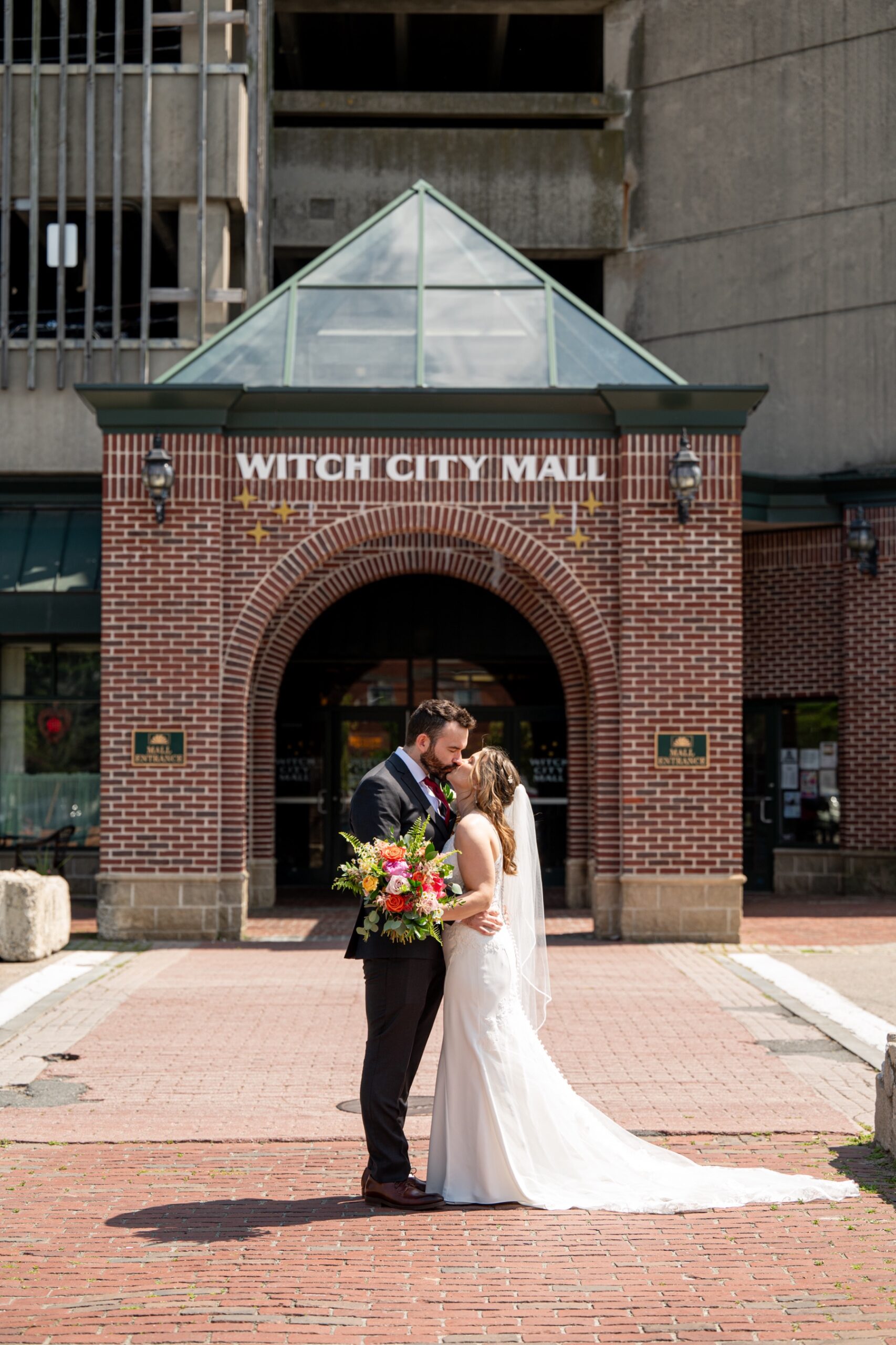 bride and groom standing in front of witch city mall