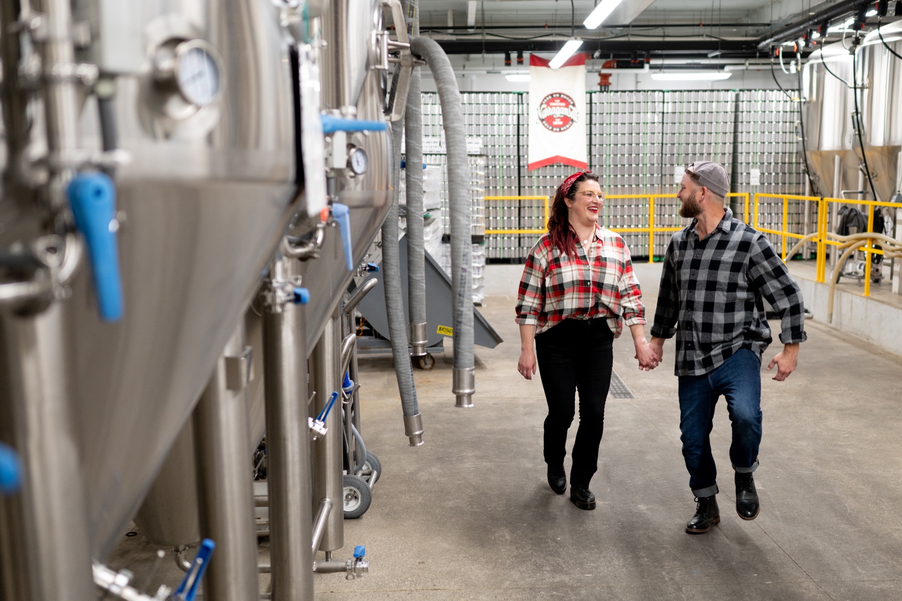 couple holding hands and walking through narragansett brewery 