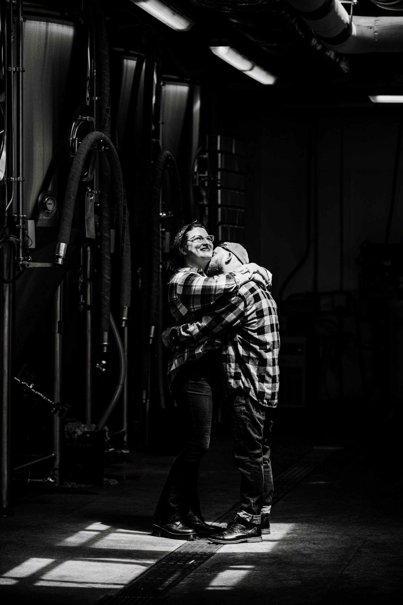 fiances hugging and smilling at narragansett brewery engagement session