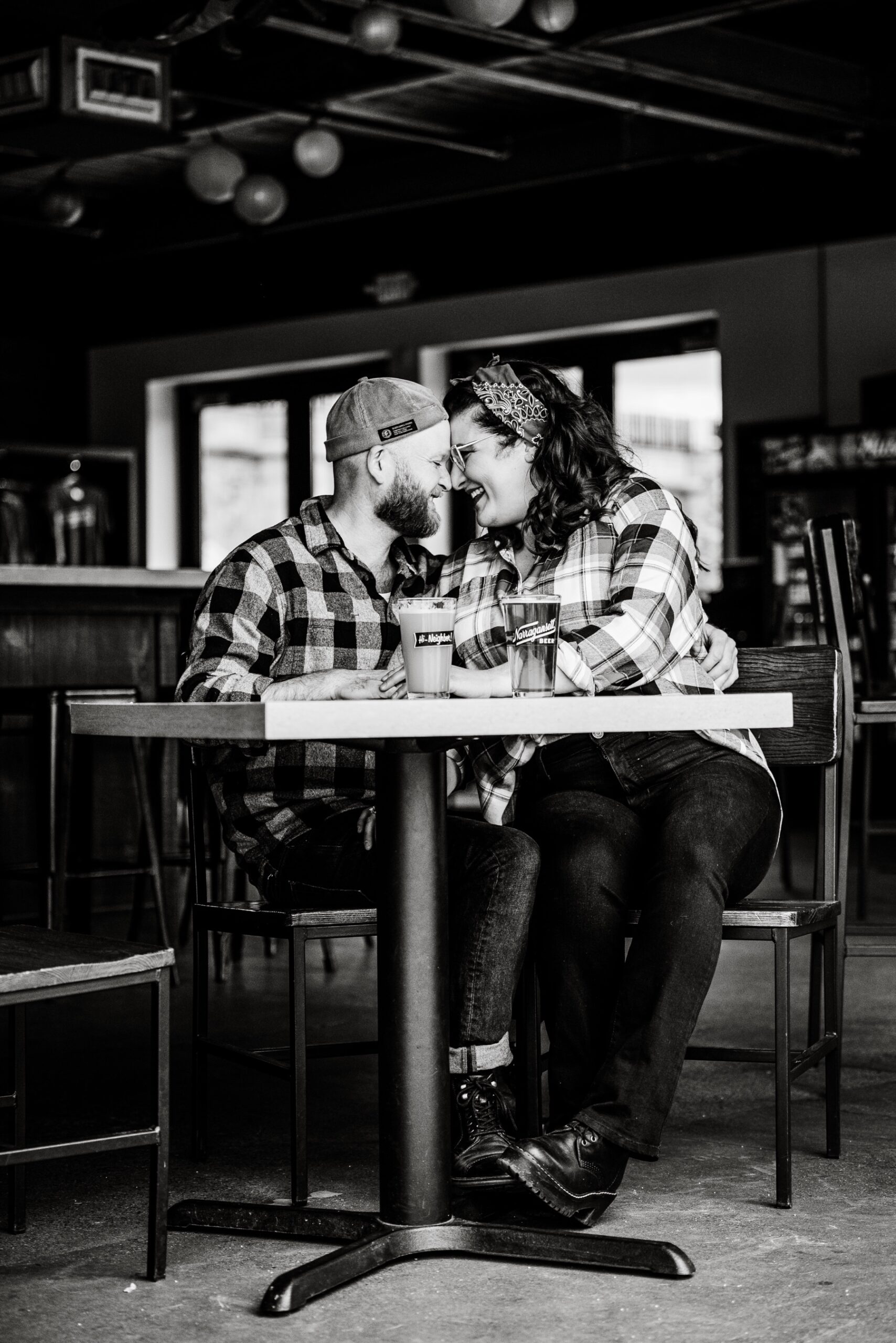 man and woman drinking beers at narragansett brewery for their engagement session