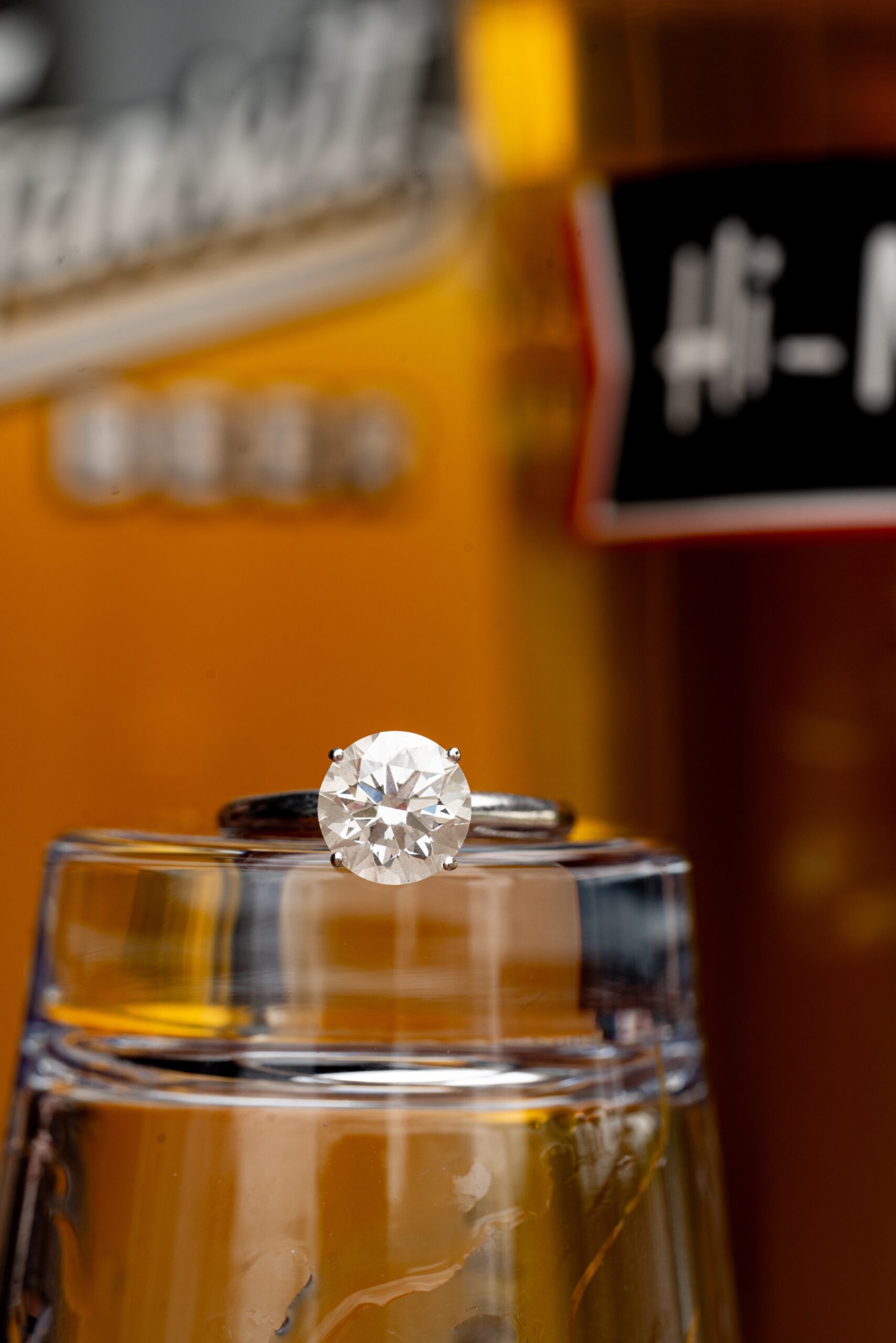 round diamond ringsitting on beer glass