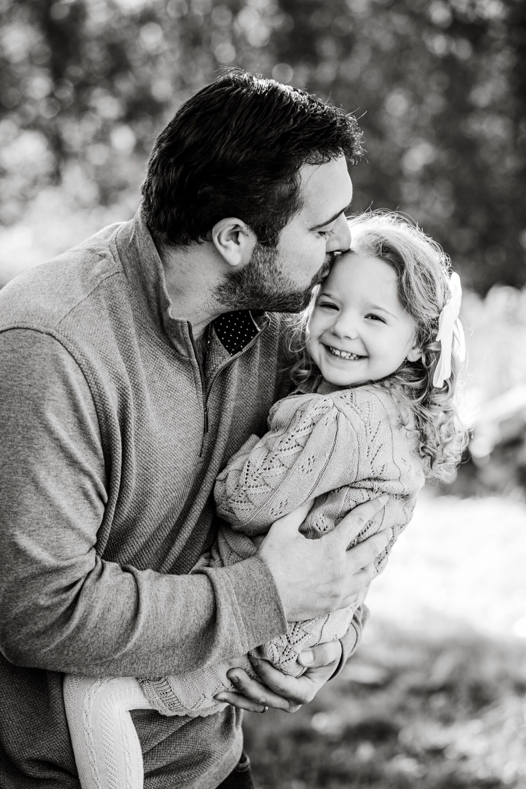 father kissing his daughter's forehead during family fall portraits