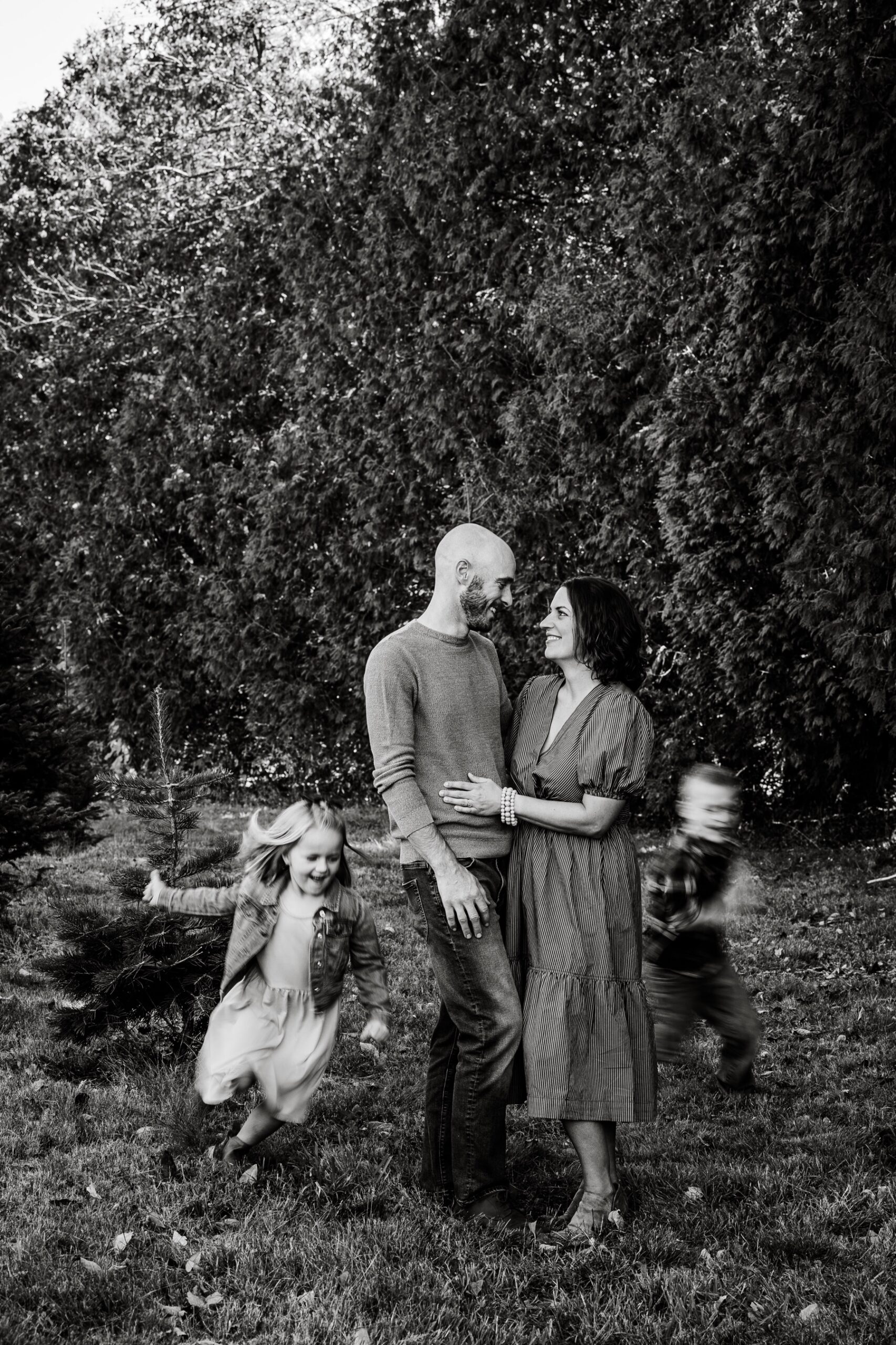 parents standing as their two kids run circles around them