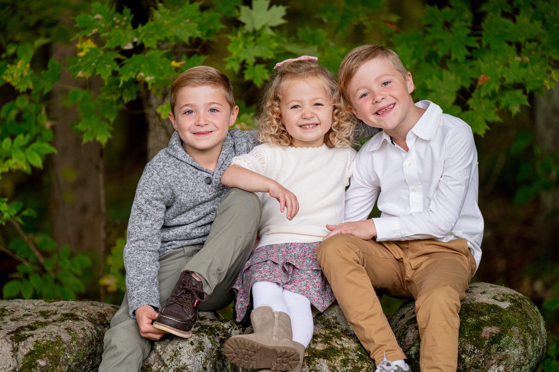 three kids sit on stone wall for Sterling MA backyard family sessions