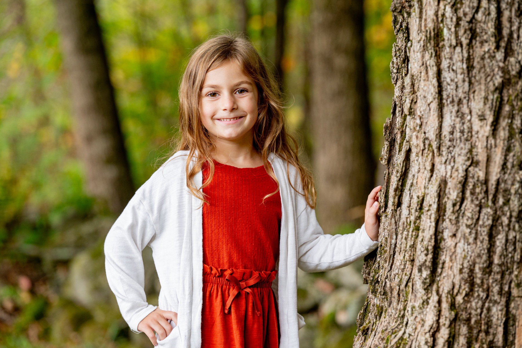 young girl in red dress stands ext to a tree during a Sterling MA backyard family session