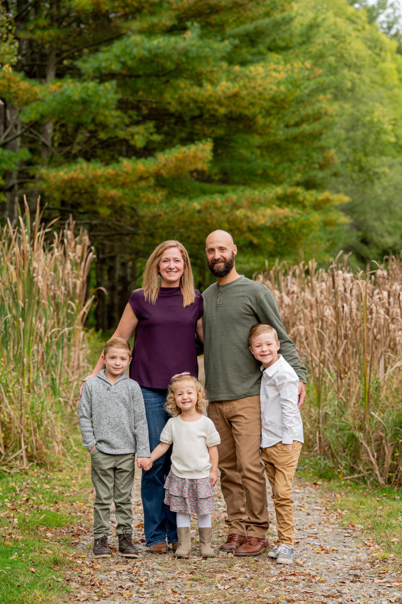 family of five stands for a portrait session in sterling ma backyard