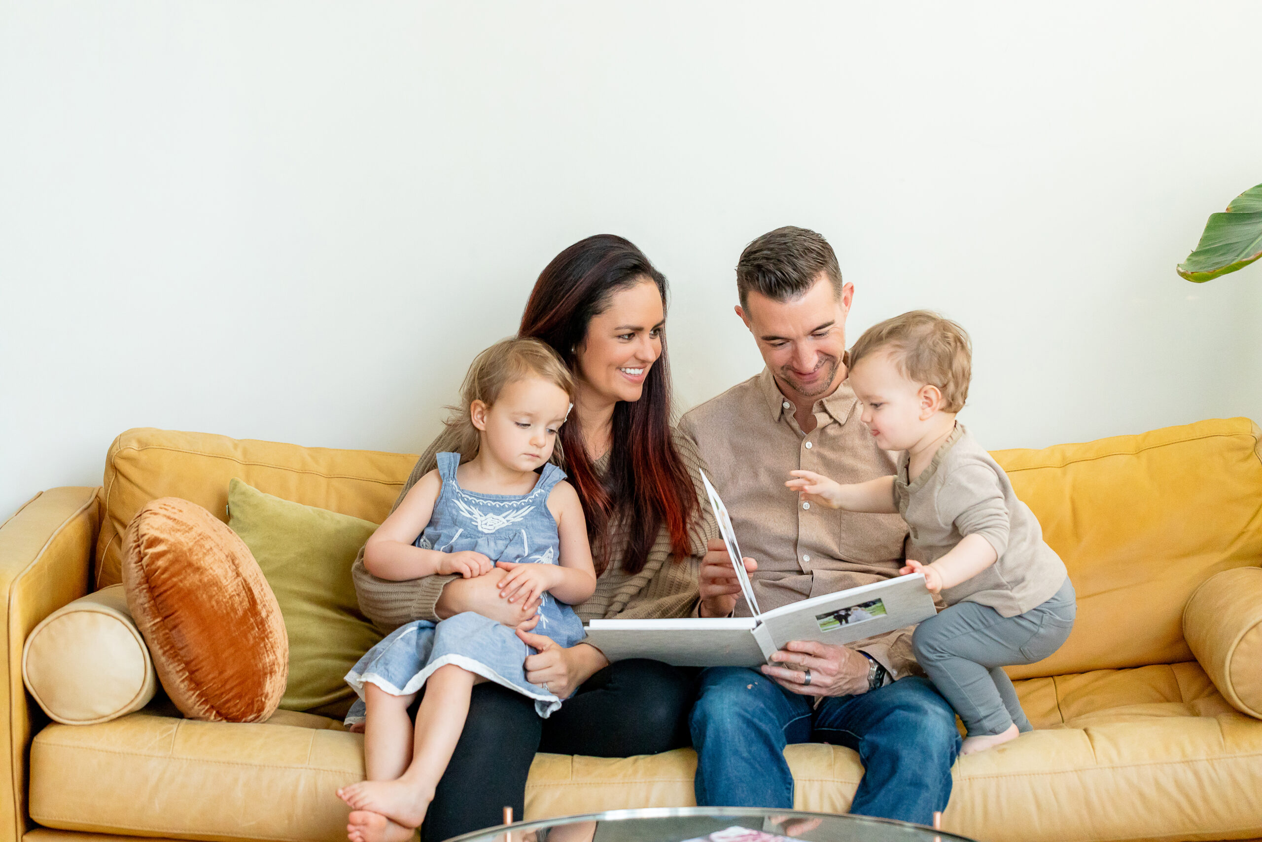 a family looking through their wedding album on the couch