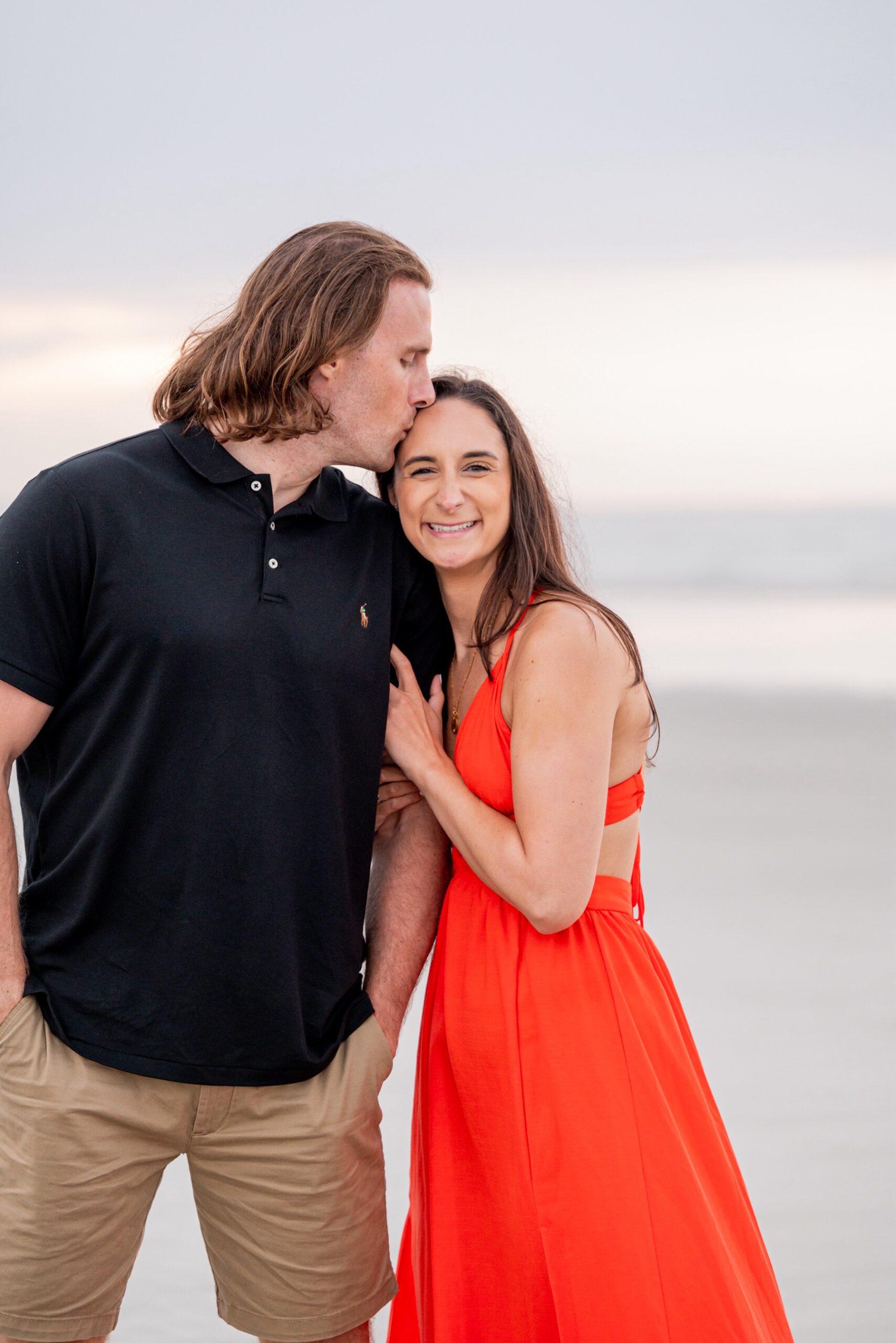 couple kissing during their beachside engagement session
