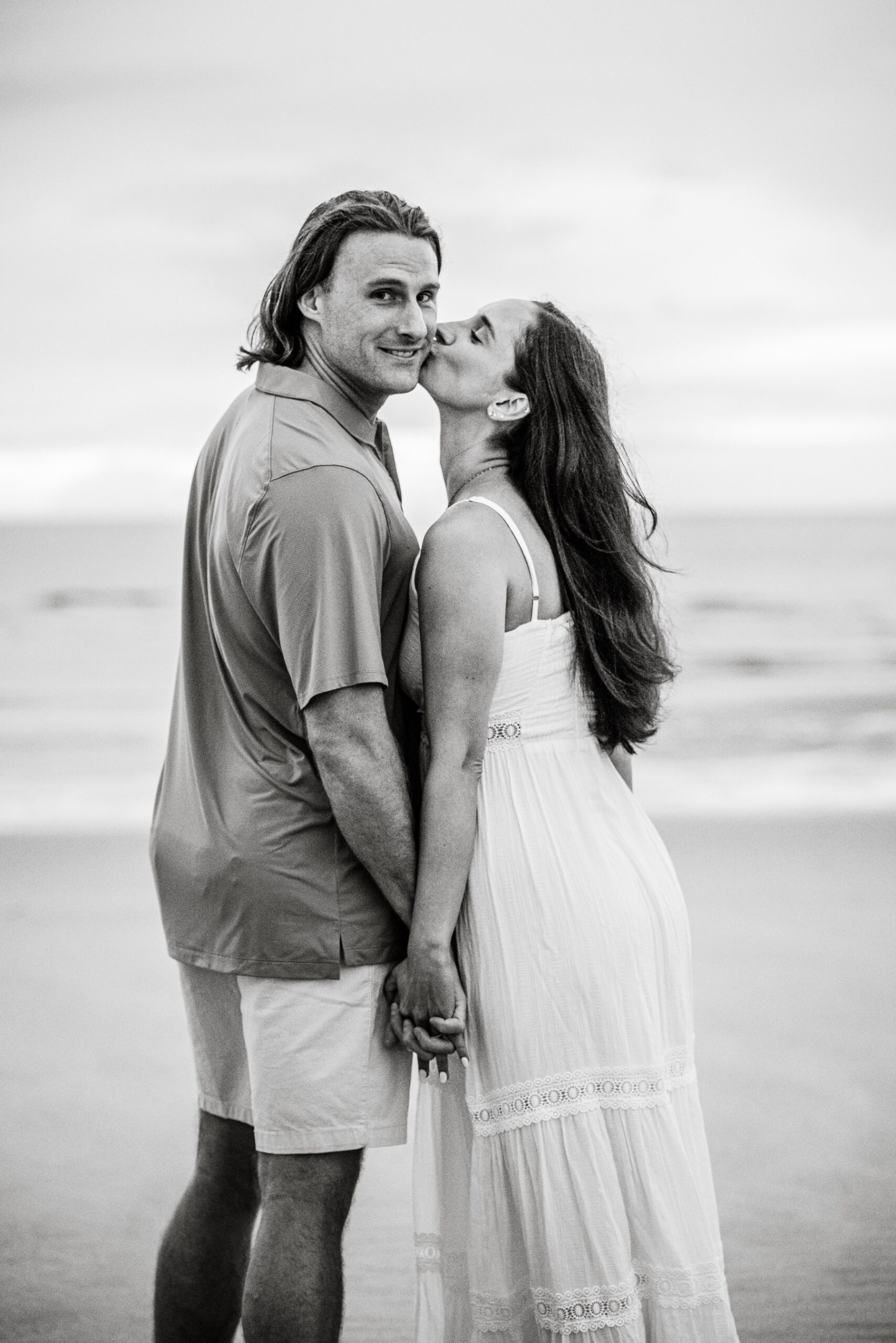 girl kisses her fiance's cheek during cape cod photo session