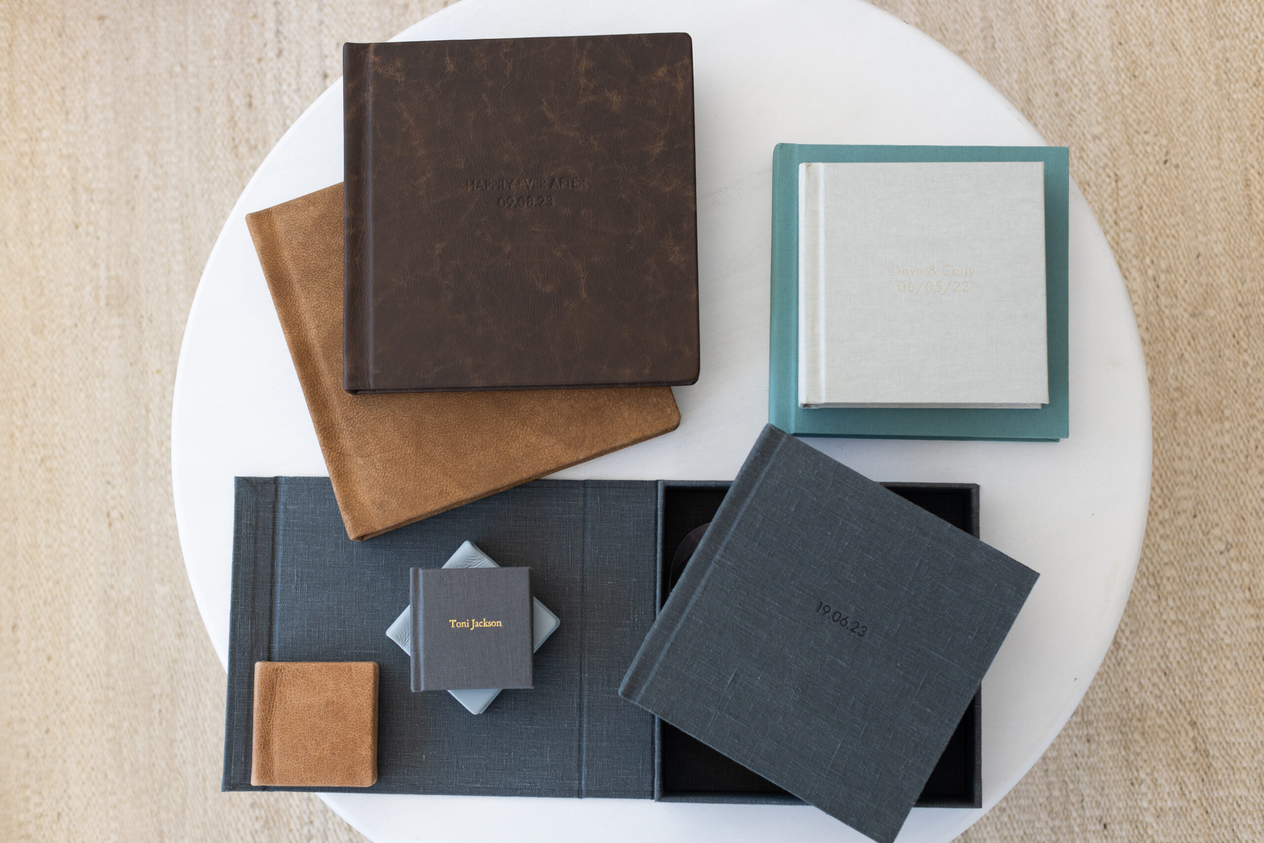 a table full of different wedding album designs and sizes 