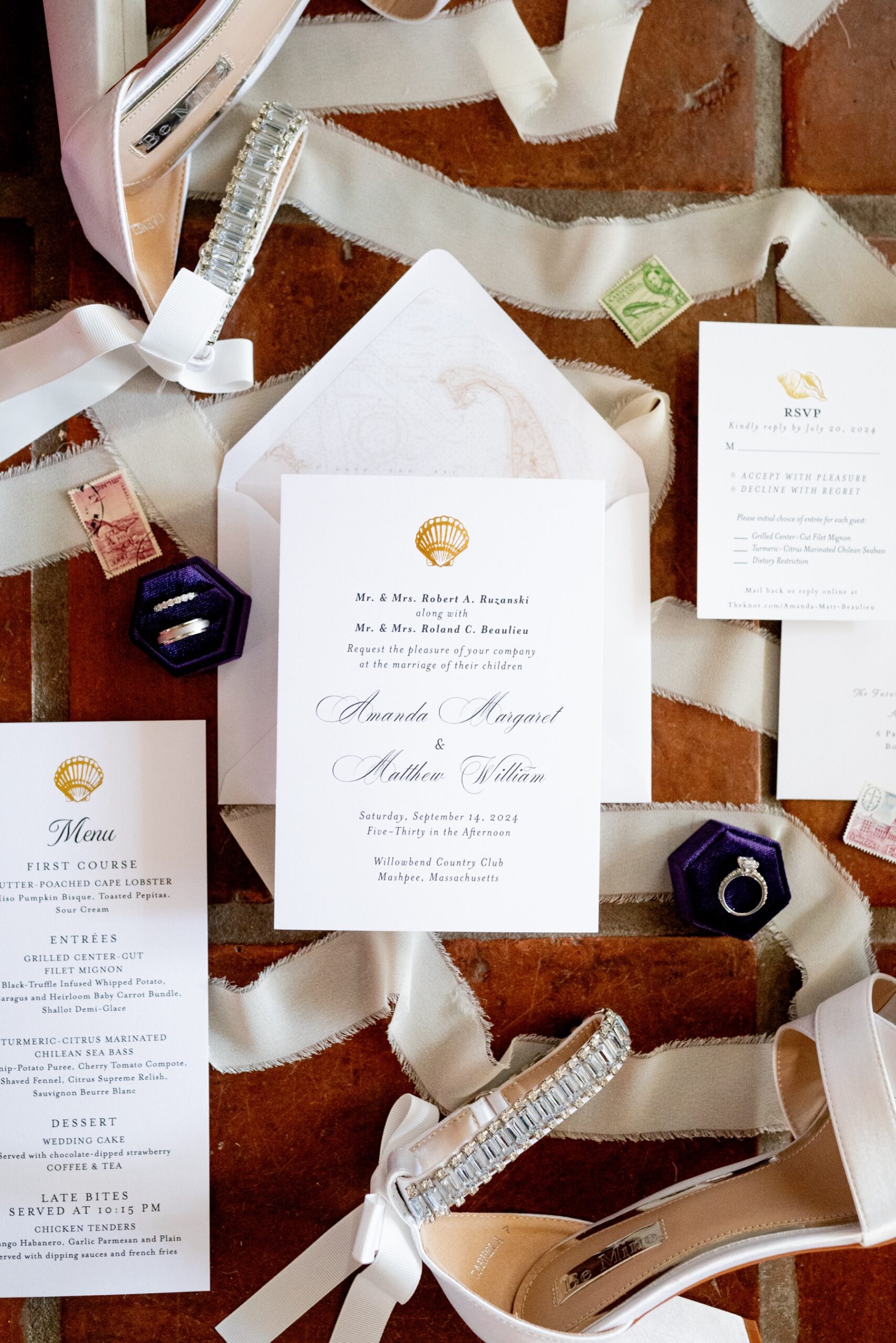 flay lat of white wedding invites and wedding rings and white ribbon