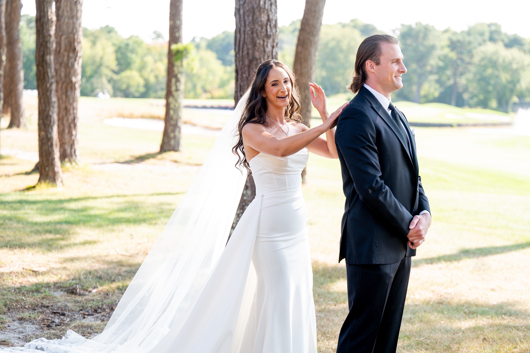 bride standing behind the groom before their first look 