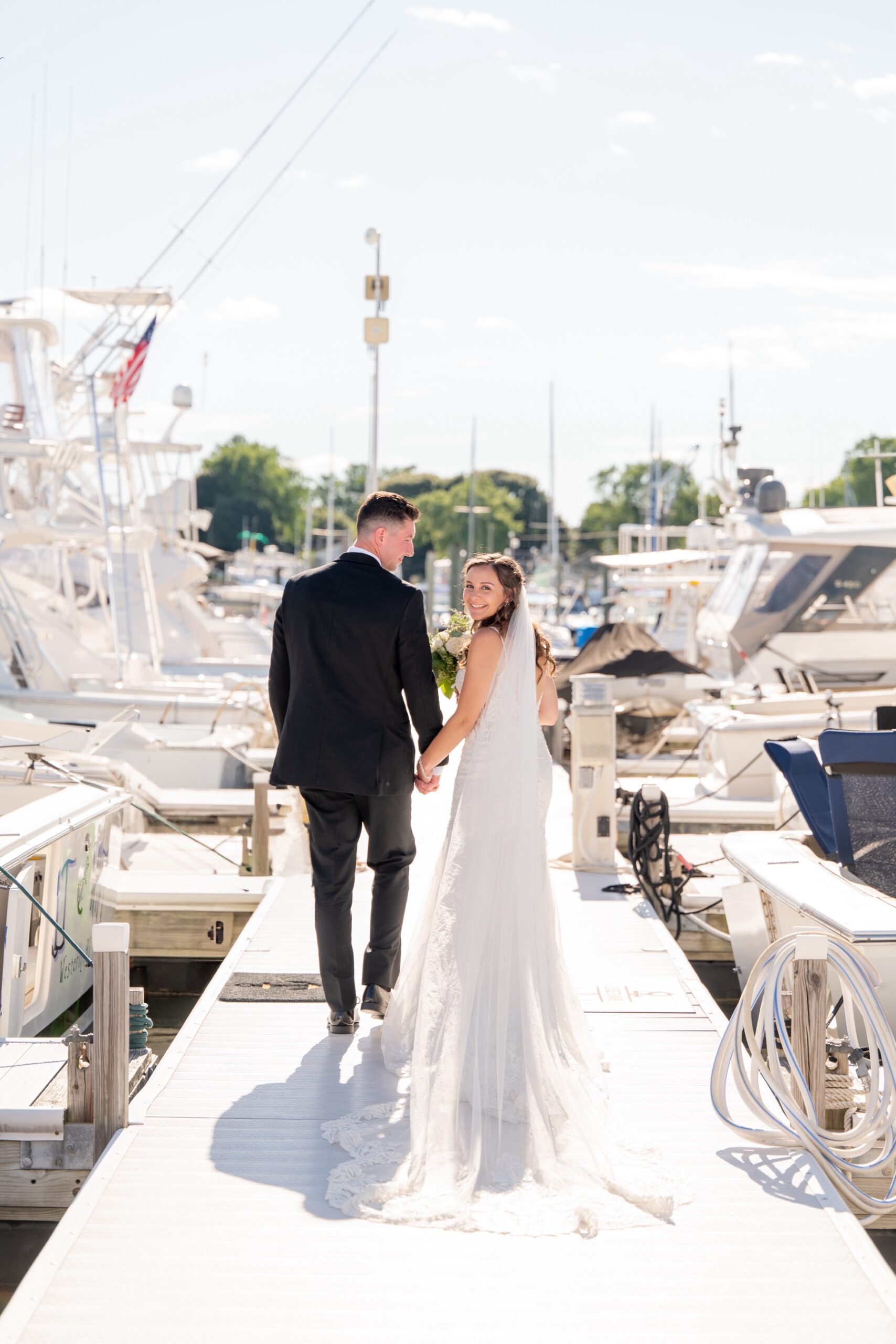 bride and groom walking along the marina of Harbor Lights after their Wedding ceremony