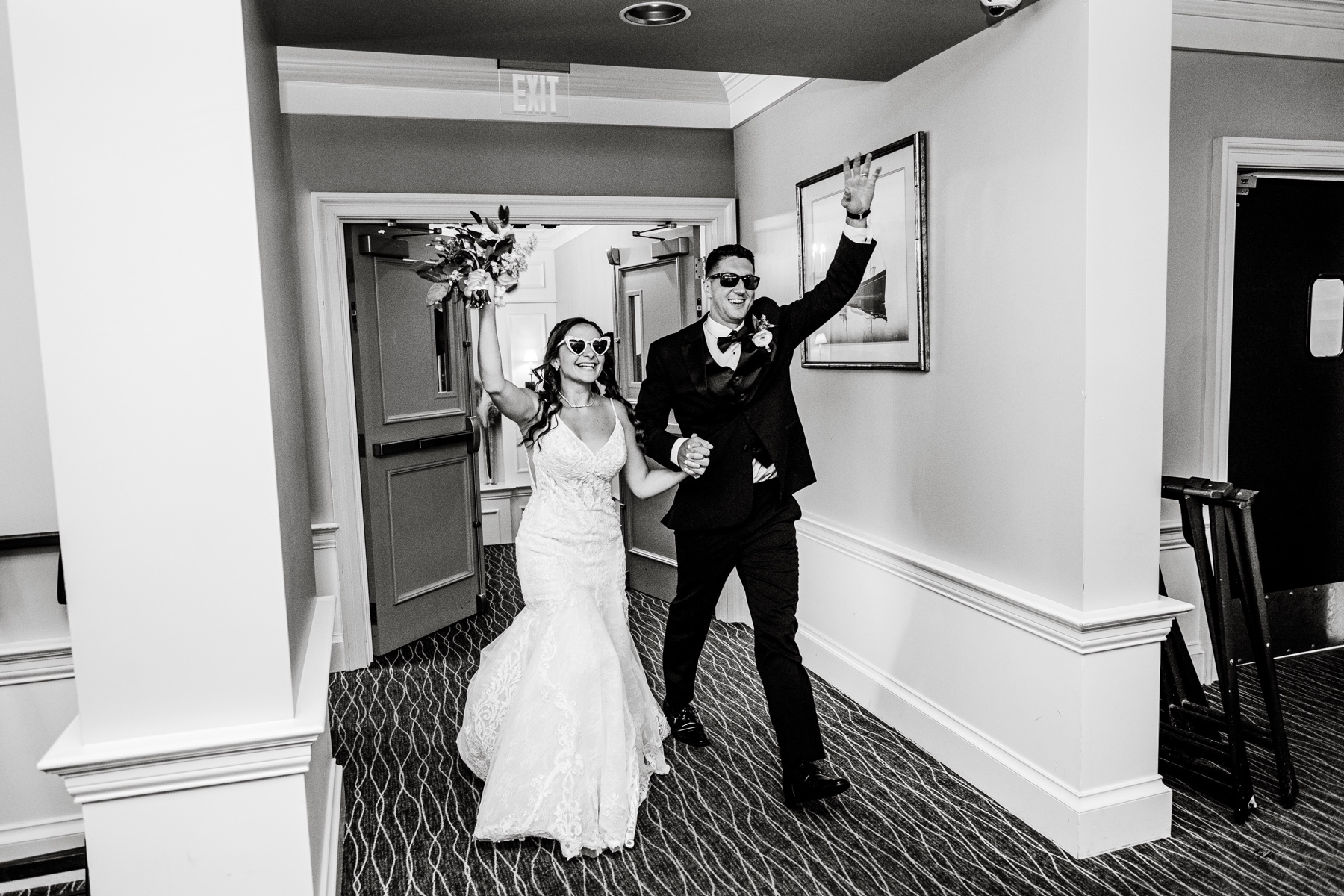 bride & groom entering their wedding reception wearing sunglasses