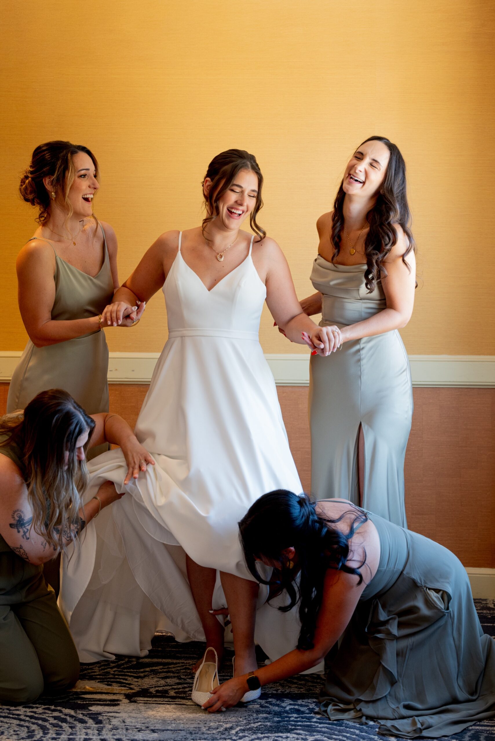 bride & bridesmaids laughing as they get ready for wedding ceremony