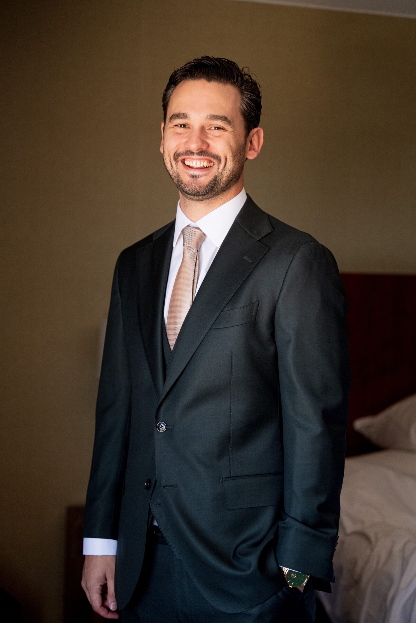 groom smiling at the camera before wedding ceremony 