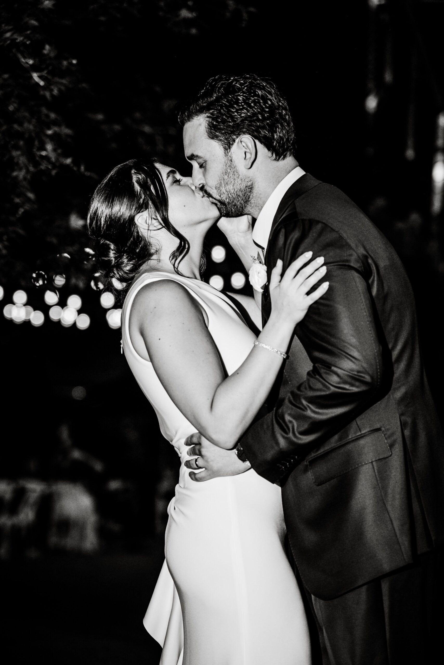 close up of bride and groom kissing after their wedding reception