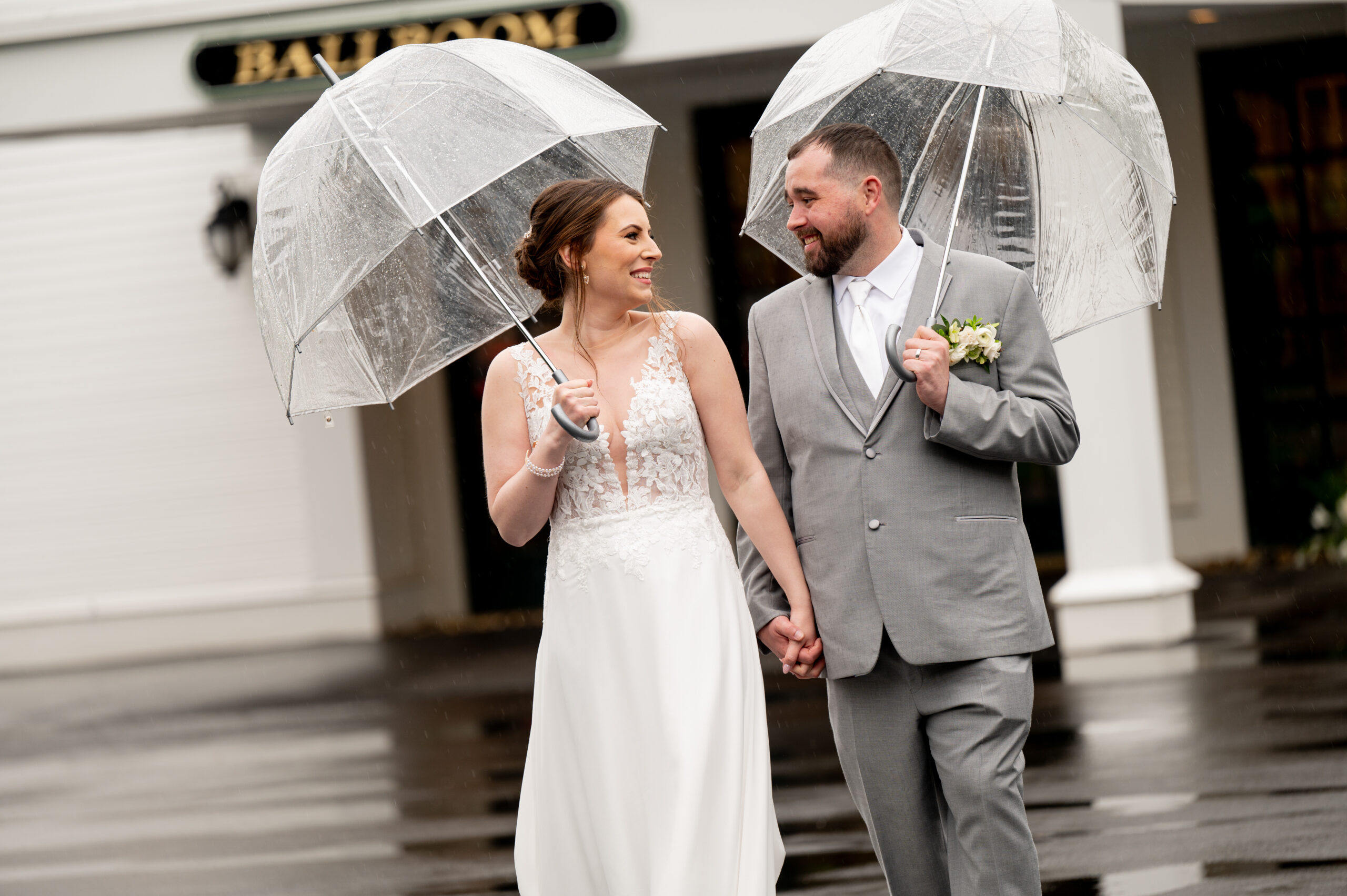 bride & groom walking with umbrellas during a busy wedding day timeline with rain plans