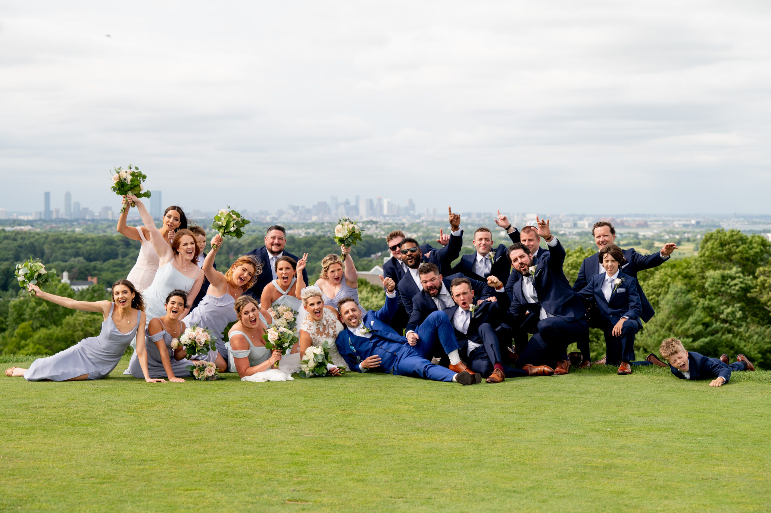 wedding party group photo with boston skyline behind them 