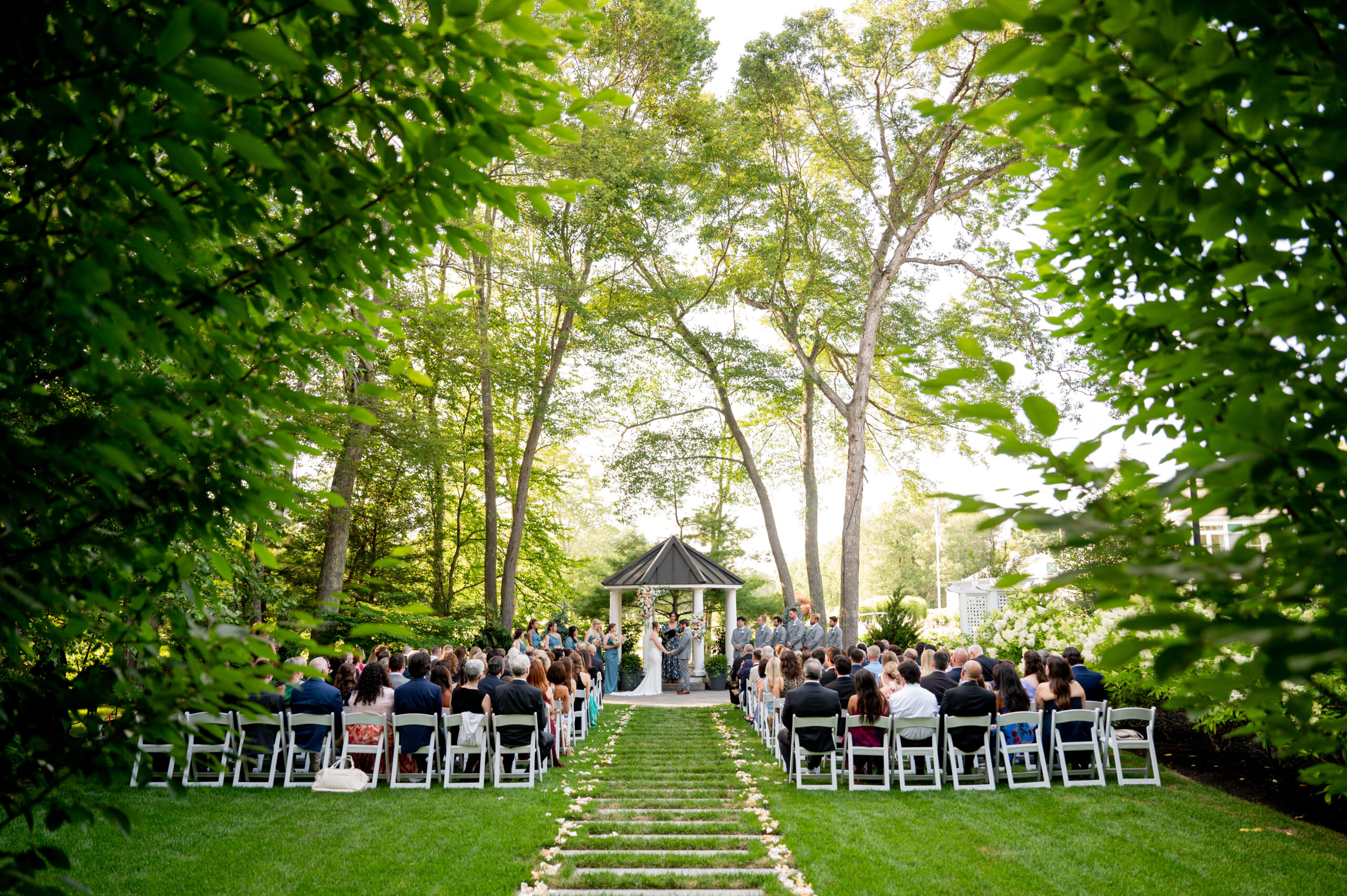 a wedding ceremony surrounded by green trees and grass