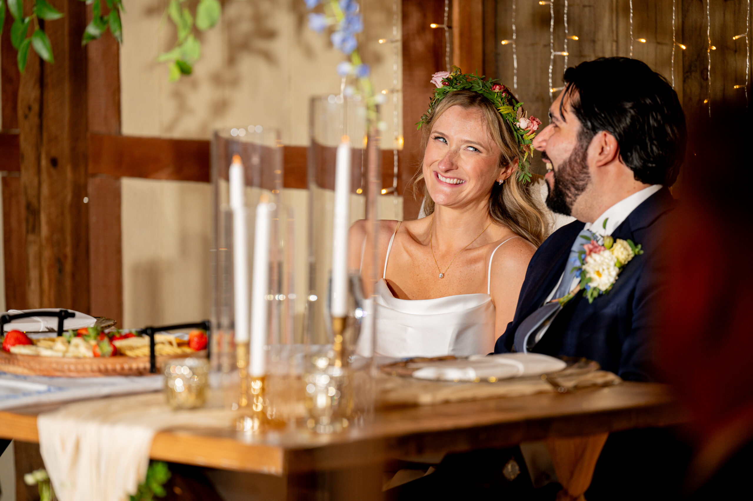 Bride and groom exchanging smiles at dinner table