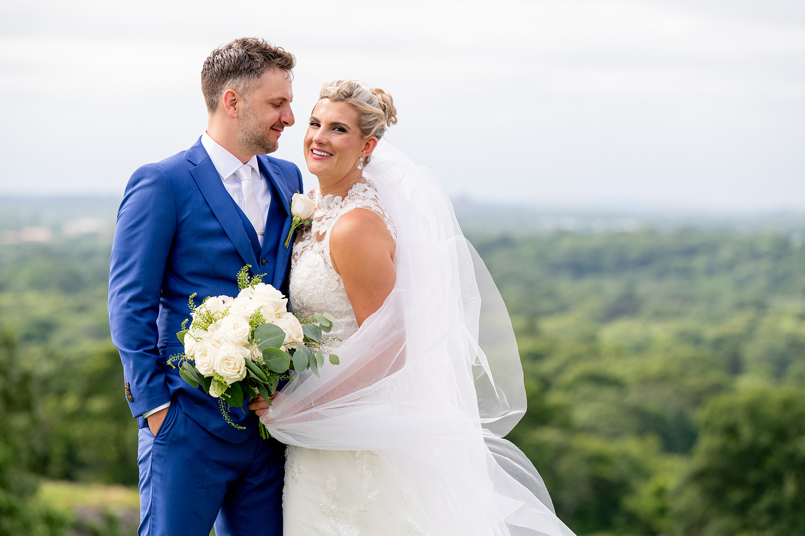 Bride and groom with veil wrapped around bride in flattering way