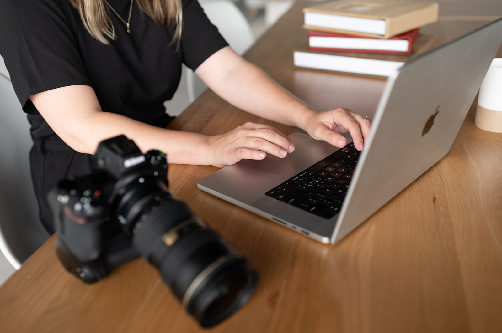 Person sitting at table with laptop and camera