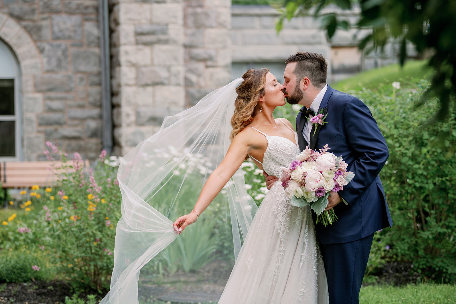 Couple kissing with brdal veil flowing