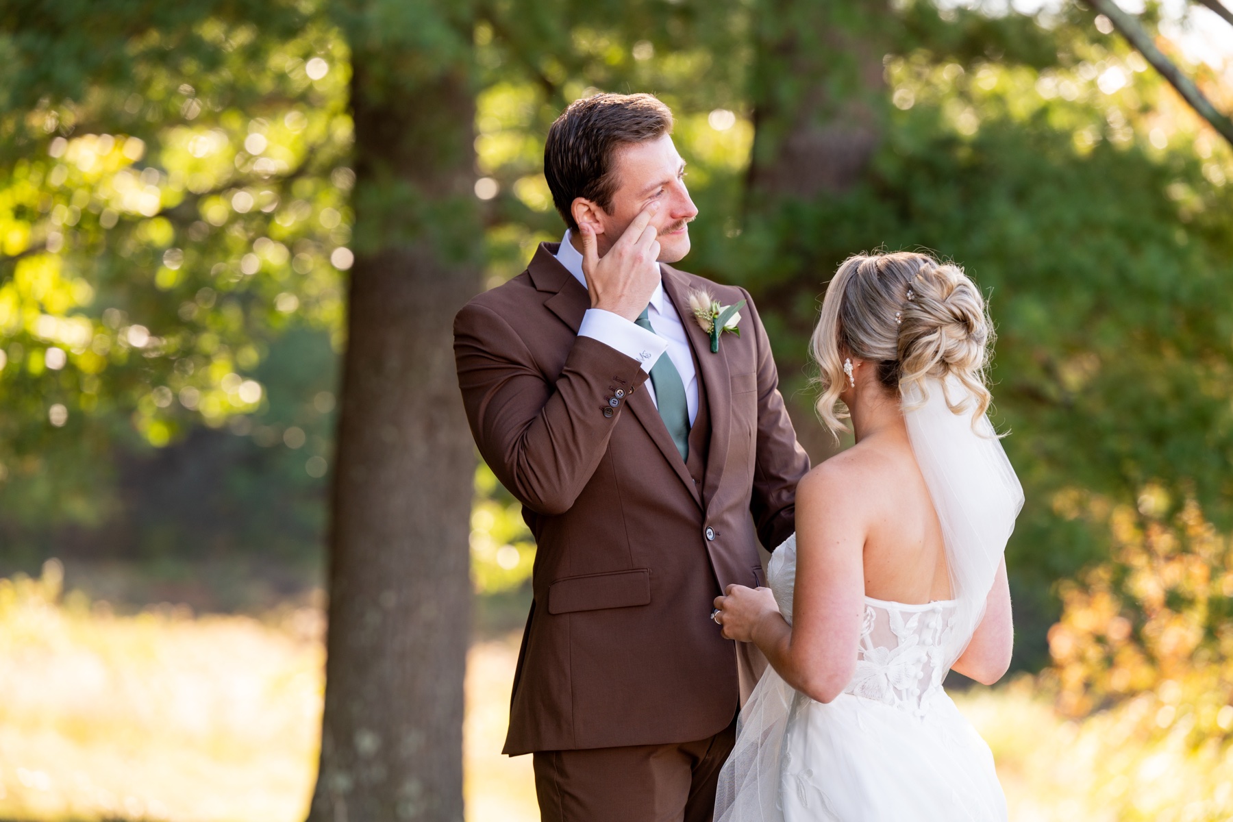 Bride and groom during first look with him wiping away tears from his eyes