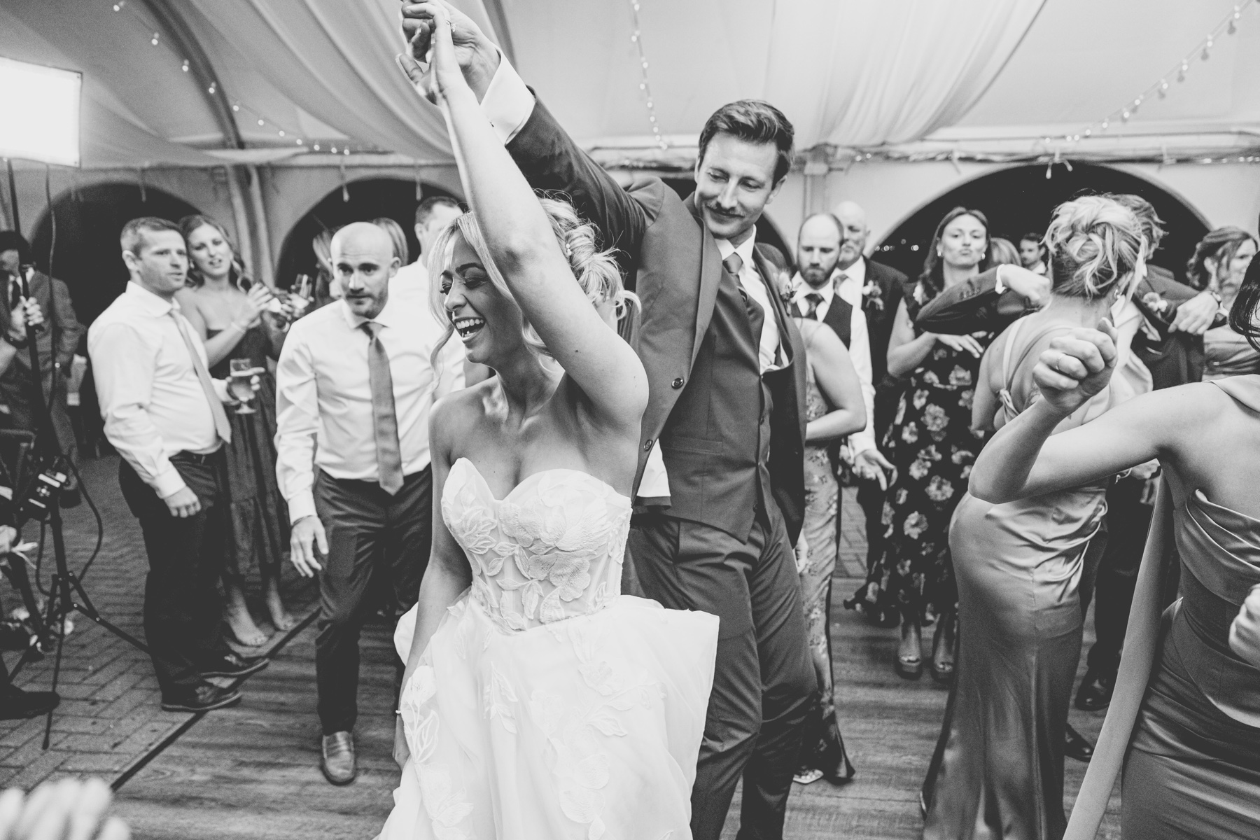 Black and white photo of bride and groom dancing together on the dance floor
