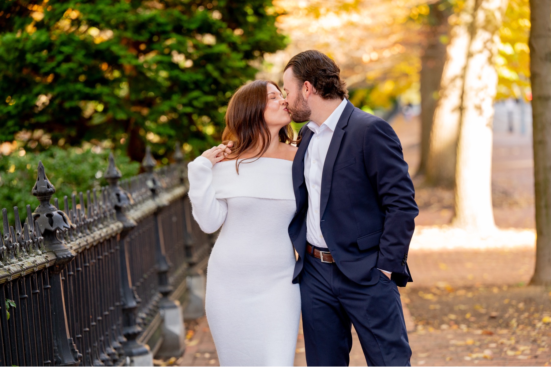 Close up of couple kissing with fall foliage in the background