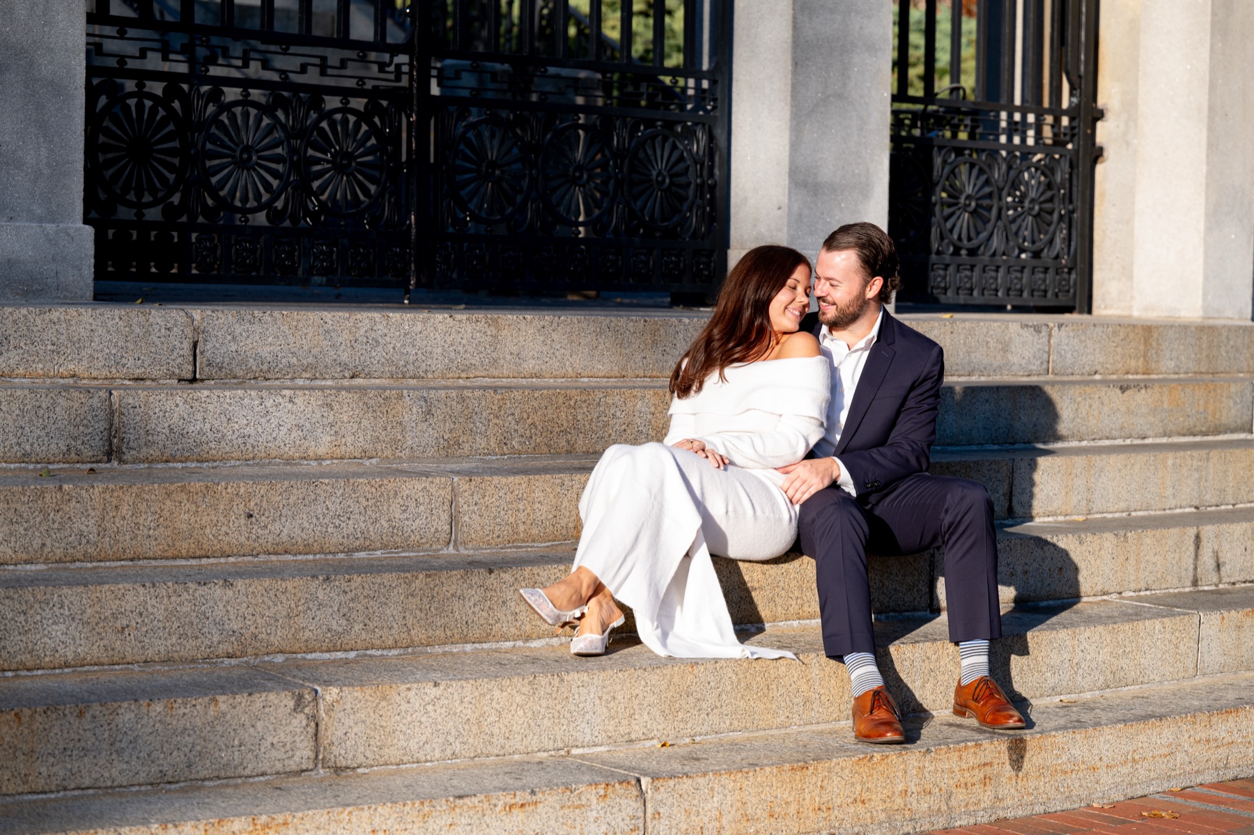 Couple sitting together closely on steps during their Boston engagement session